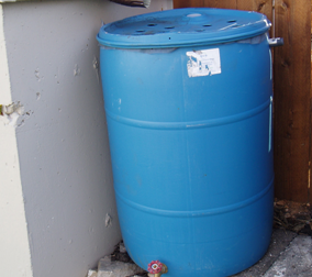 A simple rain barrel with intake from a downspout (top), a drainage spout (bottom), and an overflow spout (side).