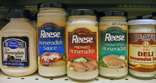 A variety of commercial prepared horseradishes on a store shelf.