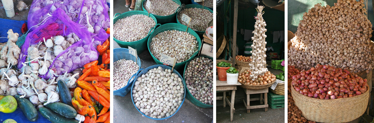 Garlic offered for sale in markets throughout the world (L-R): amid other vegetables in Peru, tubs of bulbs and separated cloves in Thailand, hanging braids in Nicaragua, and huge pile in Madagascar (behind basket of onions).